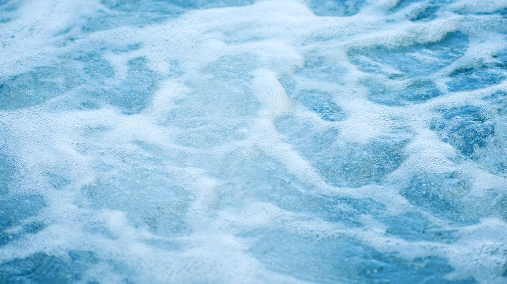 Espuma na água (superfície apresenta bolhas).